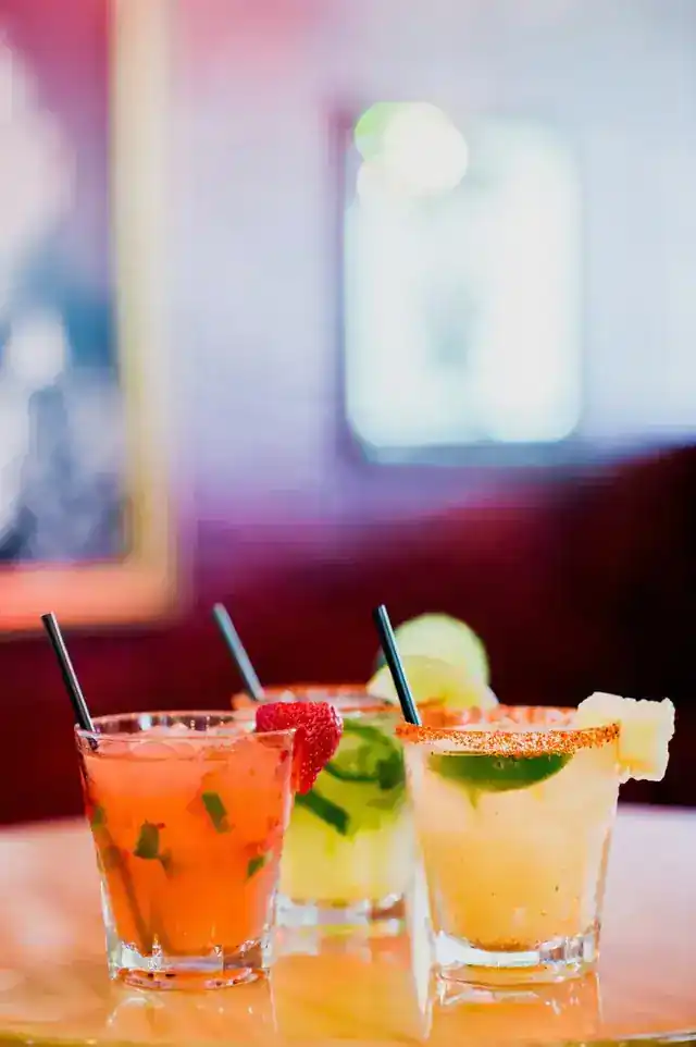 Two margaritas on the table in front of a red booth