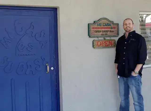Owner Ryan Moore standing at Mi Casa's original blue door