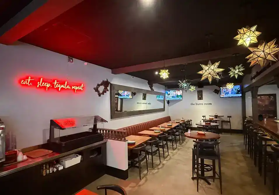 The Burro Room bar after the 2025 remodel, star lanterns and a red neon sign over the bar seating