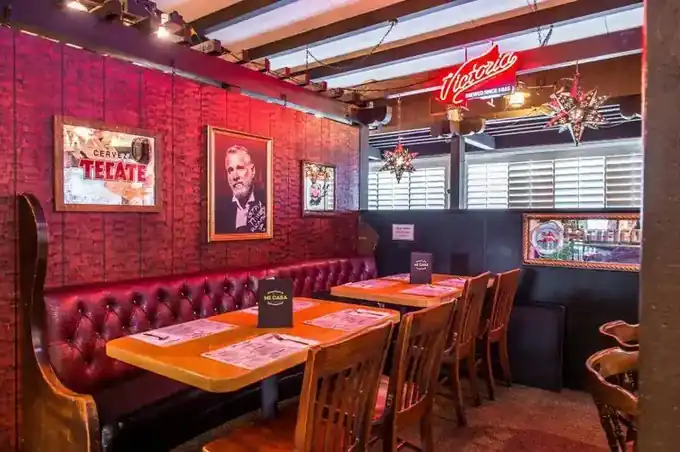 Red booths along a red brick wall in the Mi Casa dining room